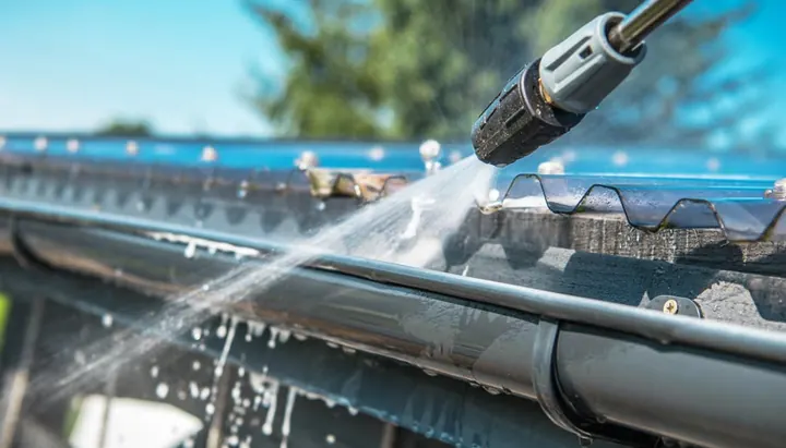Pressure washing a house gutter and downpipe