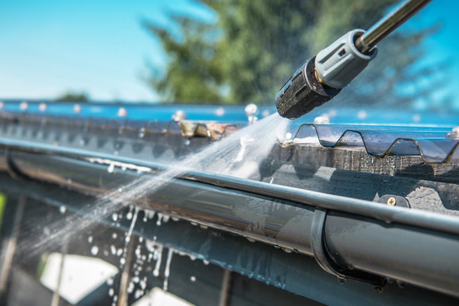 Pressure washing a house gutter and downpipe
