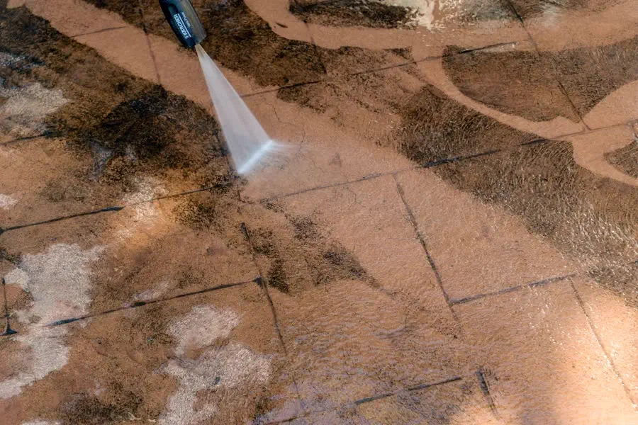 Pressure washing dirt off a paved patio